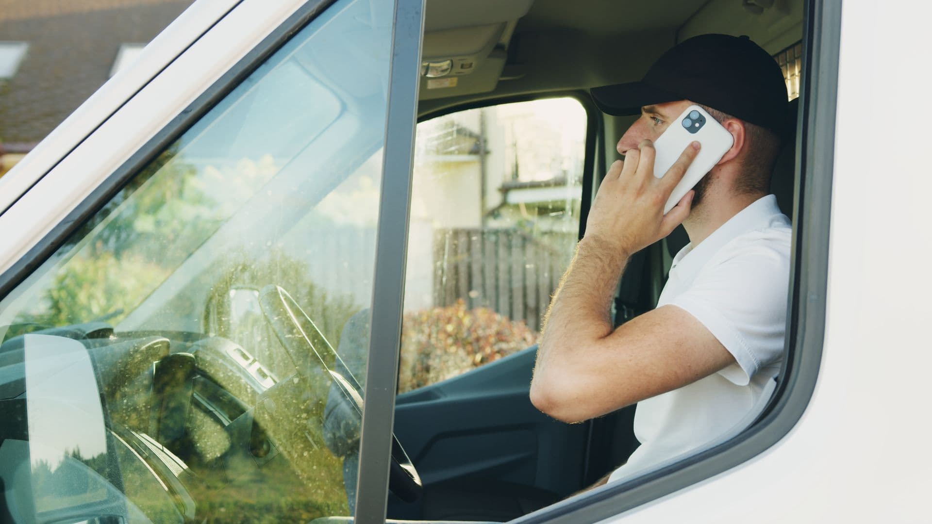 A home-services owner takes a call in his work van