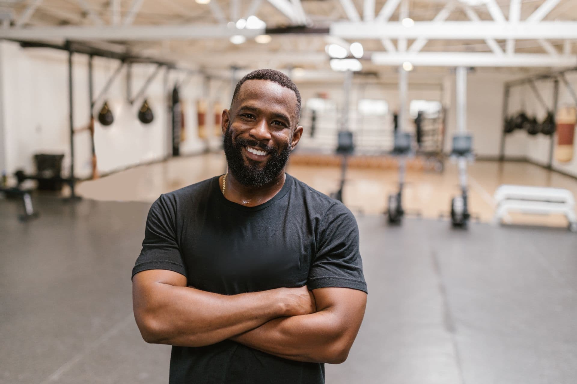 A gym owner, arms crossed, in his gym