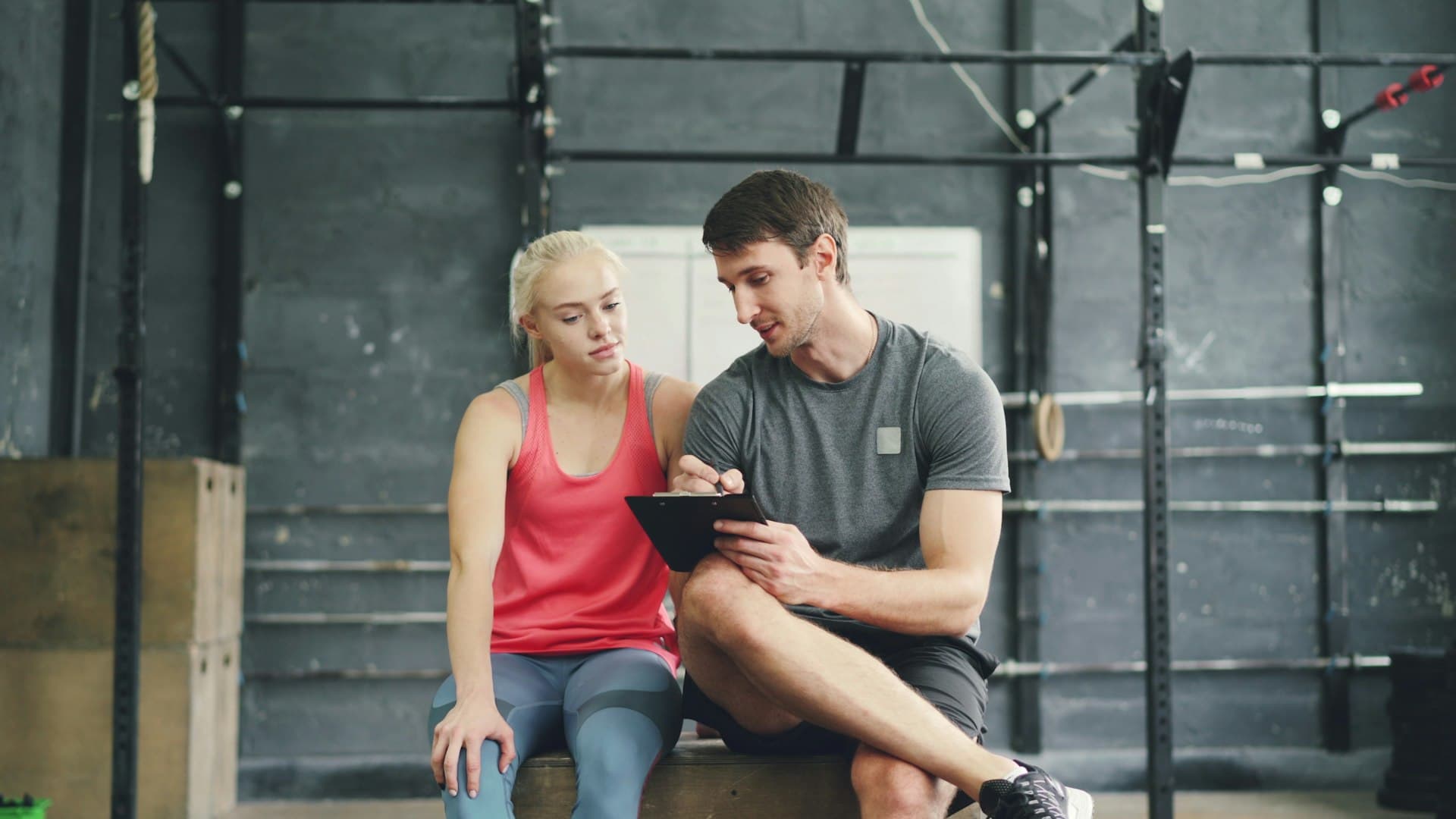 A trainer reviews a member's progress on a tablet